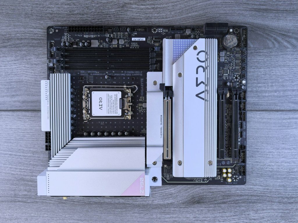 A modern computer motherboard with silver heatsinks.